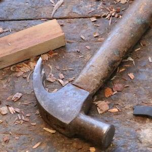 Ein Hammer und Holzspäne liegen auf einer Werkbank